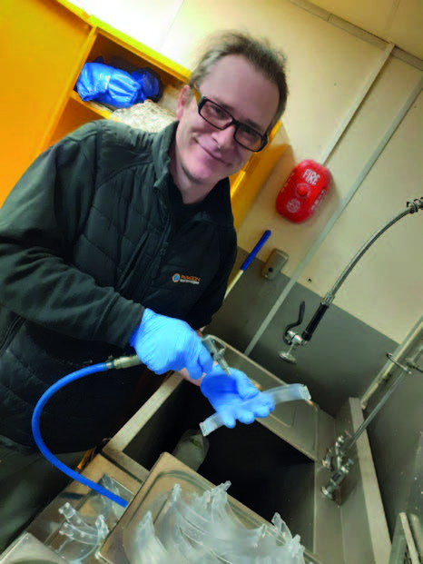 Paragon employee Angus Oxborough cleans off head bands newly printed off the NEO800