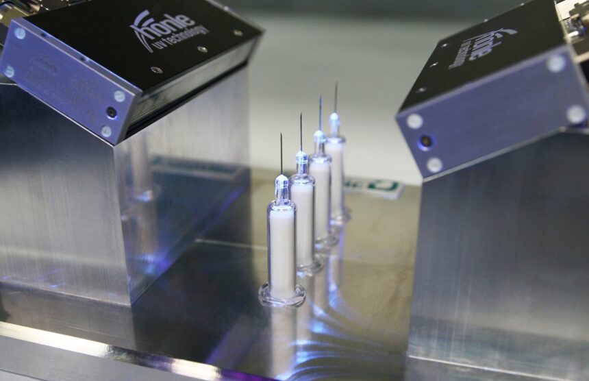 The uv adhesive bonding the needles into the needle hubs is being cured under uv light