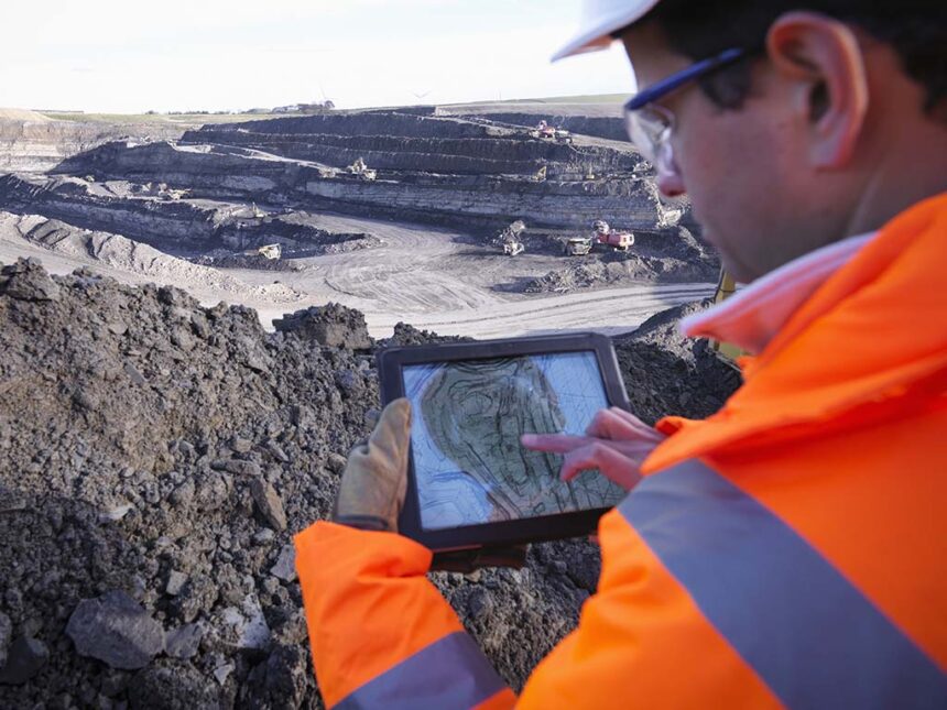 Engineer looking at digital scan of surface mining site on a tablet. Picture credit: Getty Images