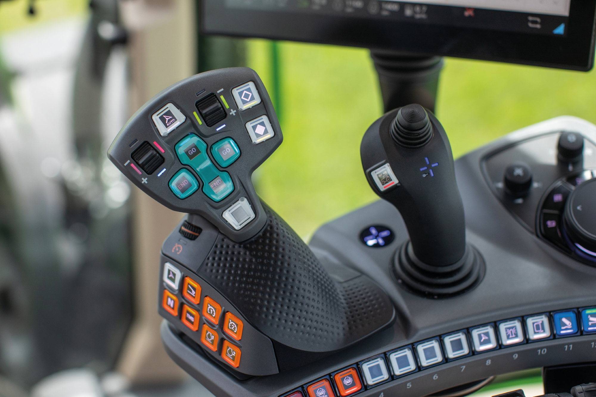 The 3L joystick (r.) enables simultaneous control of three loader functions plus extra functions freely assignable to up to 27 levels